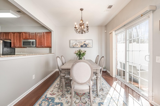 dining space featuring a notable chandelier and hardwood / wood-style flooring