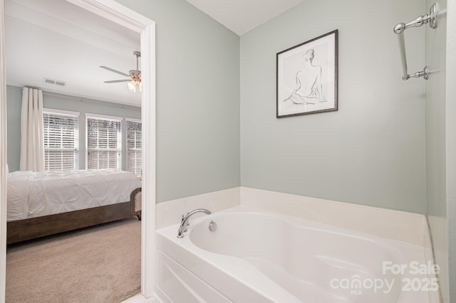 bathroom with a washtub and ceiling fan