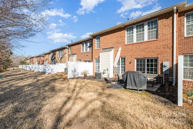 rear view of property featuring cooling unit and a yard