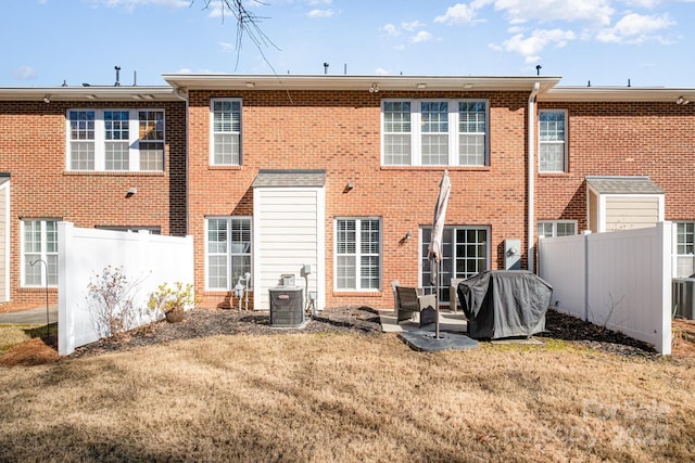 back of house with central AC and a yard