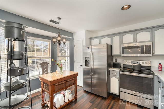 kitchen with stainless steel appliances, dark hardwood / wood-style flooring, hanging light fixtures, and gray cabinetry