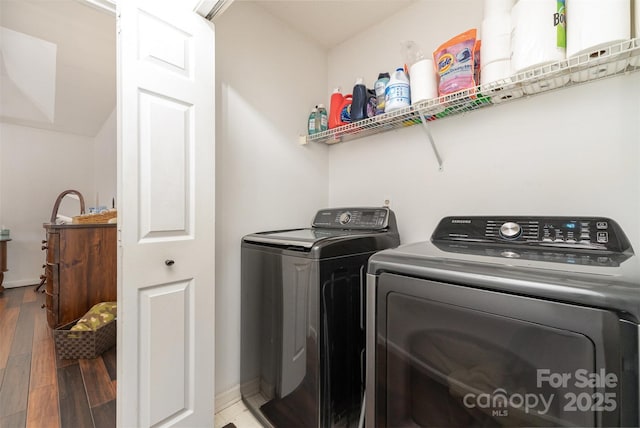 clothes washing area with washing machine and clothes dryer and wood-type flooring