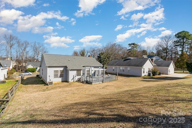 back of house with a yard and central AC