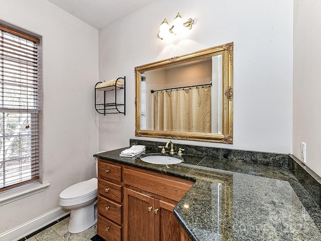 bathroom featuring vanity, toilet, and walk in shower