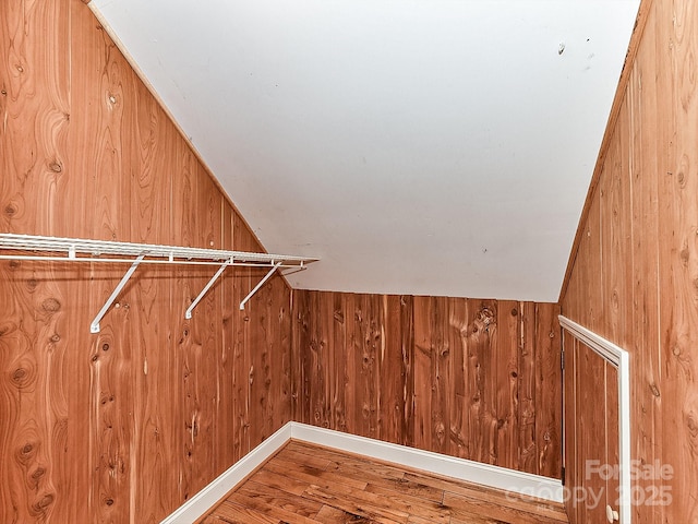 spacious closet with lofted ceiling and hardwood / wood-style flooring