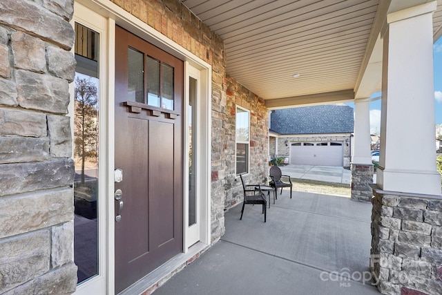 view of patio featuring a porch and a garage