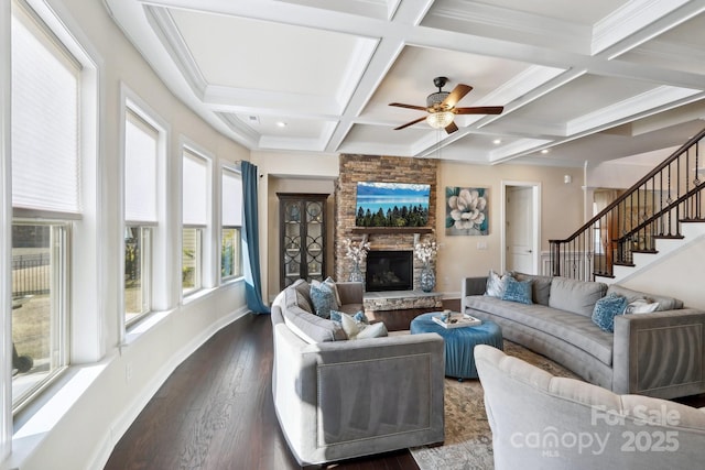 living room featuring coffered ceiling, dark hardwood / wood-style floors, beamed ceiling, ceiling fan, and a fireplace