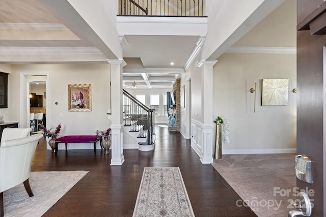 entryway featuring ornate columns, coffered ceiling, dark hardwood / wood-style flooring, and beam ceiling