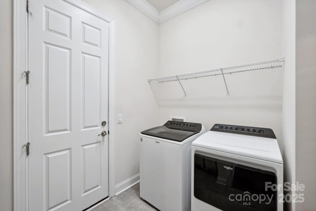 washroom with ornamental molding and washing machine and dryer