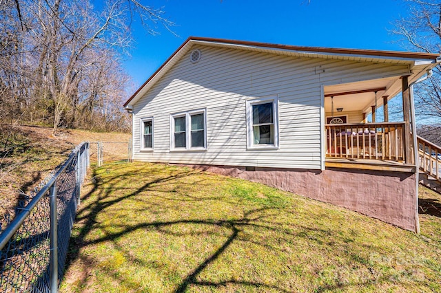 view of property exterior featuring a lawn and fence