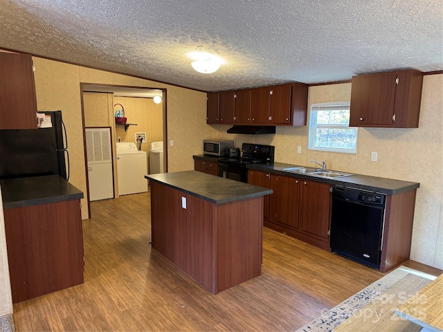 kitchen with sink, a center island, light hardwood / wood-style flooring, washer and clothes dryer, and black appliances