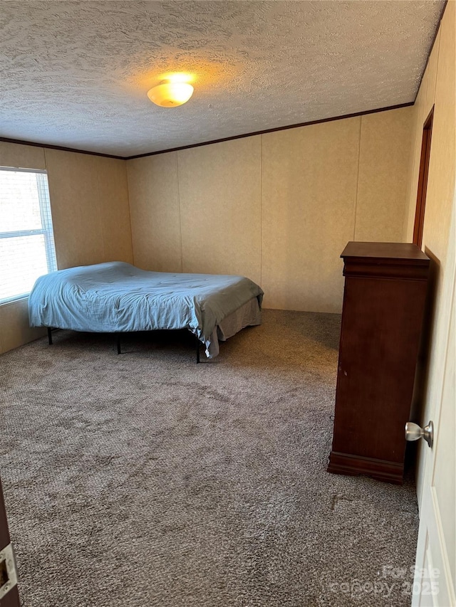 unfurnished bedroom with ornamental molding, a textured ceiling, and dark carpet