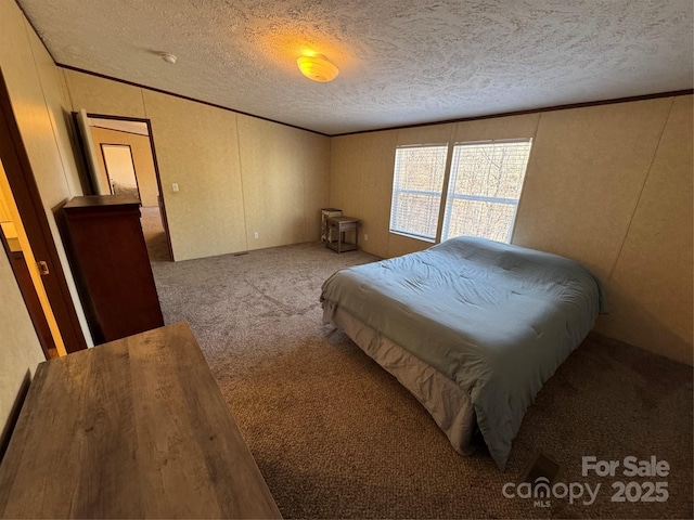 bedroom featuring crown molding, light colored carpet, and a textured ceiling