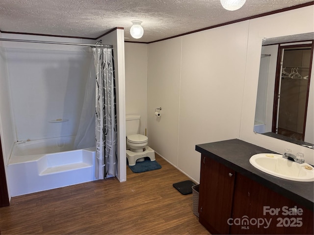 full bathroom with shower / bathtub combination with curtain, hardwood / wood-style floors, ornamental molding, a textured ceiling, and toilet