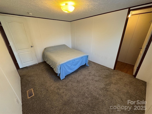 carpeted bedroom with a textured ceiling