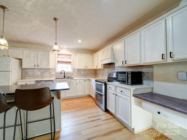 kitchen featuring pendant lighting, appliances with stainless steel finishes, tasteful backsplash, white cabinets, and custom exhaust hood