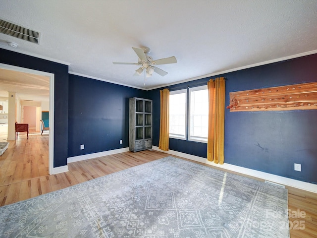 spare room featuring ornamental molding, ceiling fan, and light wood-type flooring