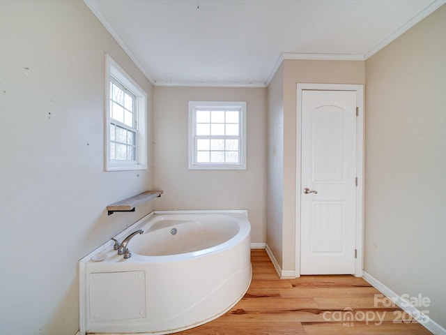 bathroom featuring hardwood / wood-style flooring, crown molding, and a bath