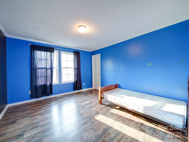 unfurnished bedroom featuring crown molding, wood-type flooring, and a textured ceiling