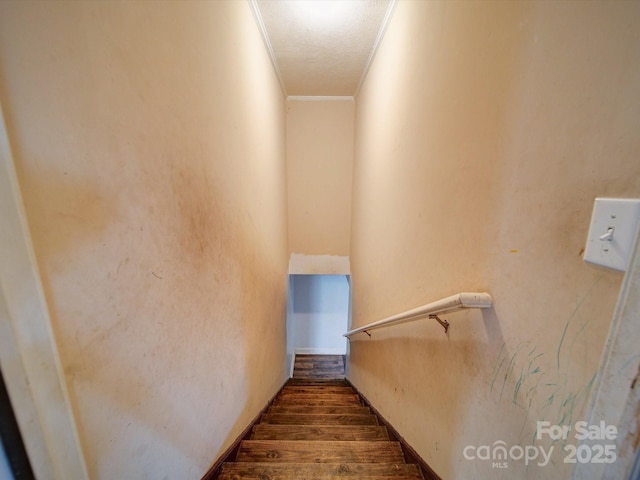 staircase with ornamental molding and wood-type flooring