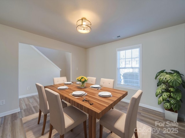 dining space with visible vents, baseboards, and light wood-type flooring