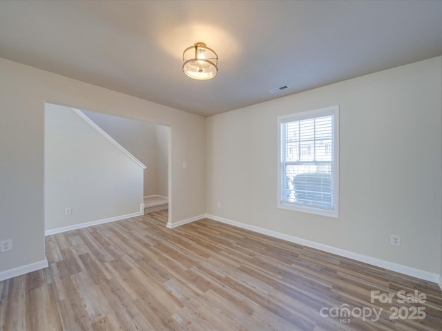 unfurnished room featuring visible vents, baseboards, and light wood finished floors