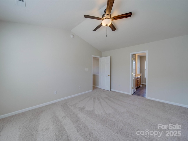 unfurnished bedroom featuring baseboards, carpet floors, ceiling fan, vaulted ceiling, and connected bathroom