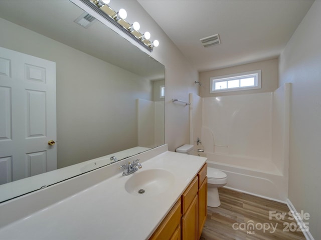 full bath featuring vanity, wood finished floors, visible vents,  shower combination, and toilet