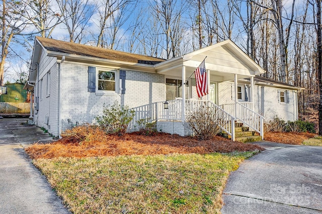 view of front of home with covered porch and a front lawn