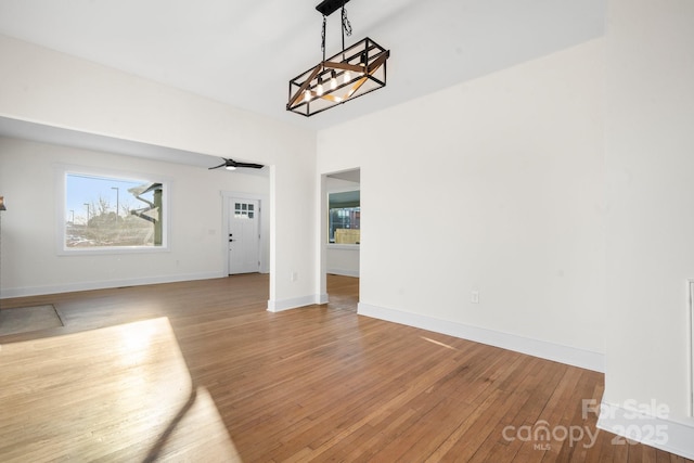 unfurnished living room with hardwood / wood-style floors and a chandelier