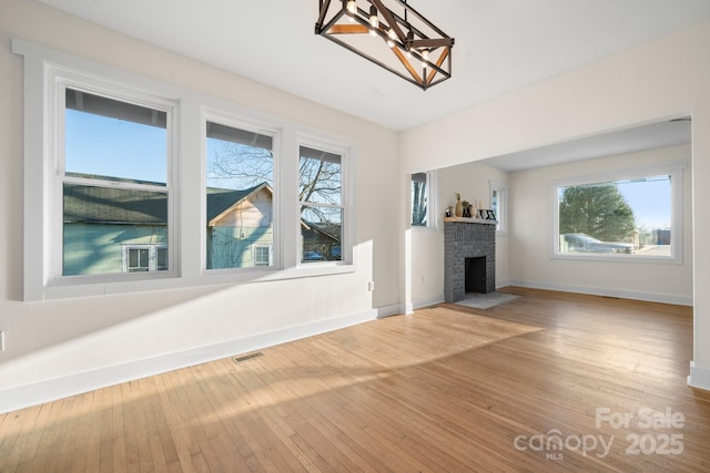 unfurnished living room featuring a brick fireplace and hardwood / wood-style flooring