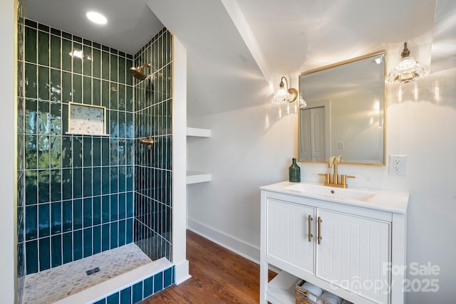 bathroom featuring vanity, hardwood / wood-style floors, and a tile shower