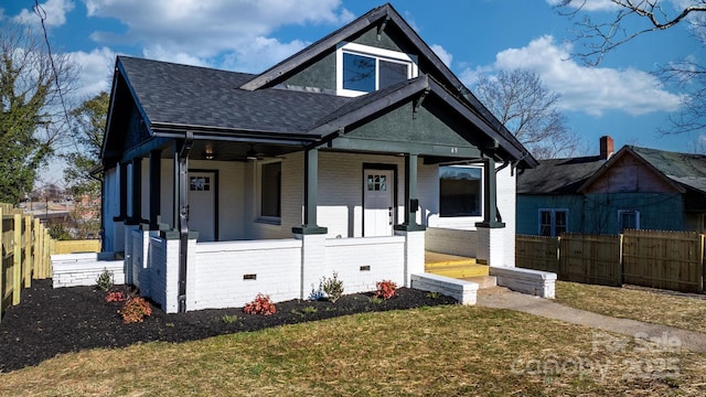 bungalow-style home with covered porch and a front lawn