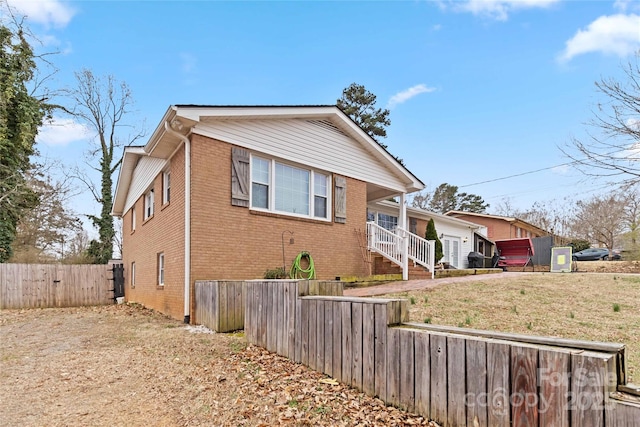 bungalow with a fenced front yard and brick siding