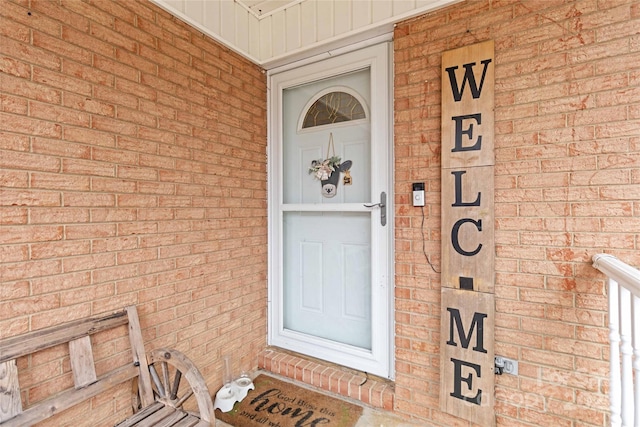 view of exterior entry featuring brick siding