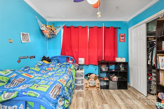 bedroom featuring light wood-style flooring, ornamental molding, and ceiling fan