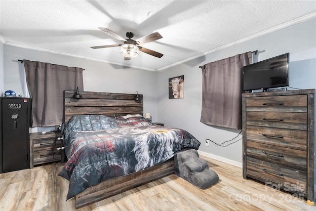 bedroom featuring light wood-style floors, baseboards, ornamental molding, and a textured ceiling