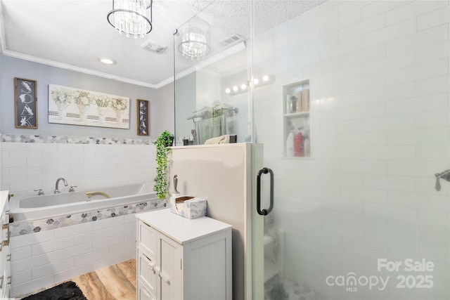 full bathroom with wood finished floors, ornamental molding, visible vents, a shower stall, and a bath