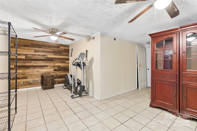 workout area featuring ceiling fan, visible vents, and wooden walls