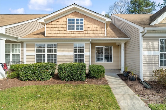 view of front of home with a front lawn and roof with shingles