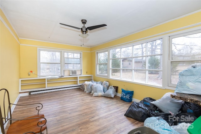 sunroom / solarium with a baseboard radiator and ceiling fan