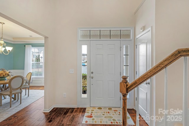 foyer entrance featuring dark hardwood / wood-style floors and a chandelier