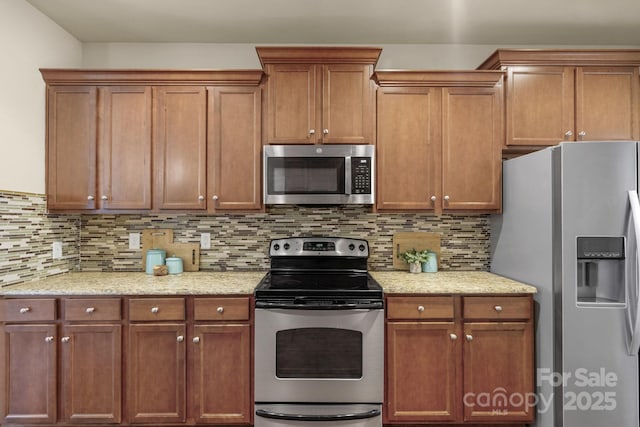 kitchen featuring light stone countertops, appliances with stainless steel finishes, and backsplash