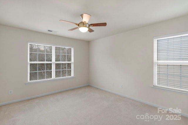 unfurnished room with light colored carpet and ceiling fan