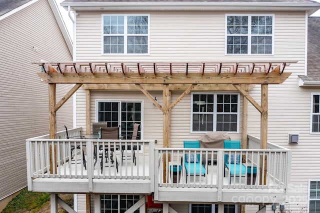 back of house featuring a wooden deck and a pergola