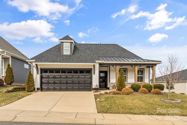 view of front of house featuring a porch, a garage, and a front lawn