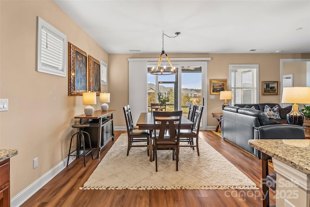 dining space featuring an inviting chandelier and dark hardwood / wood-style flooring