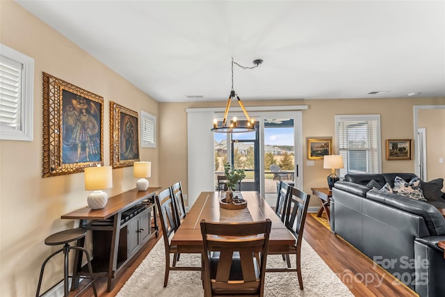 dining space featuring hardwood / wood-style floors and an inviting chandelier