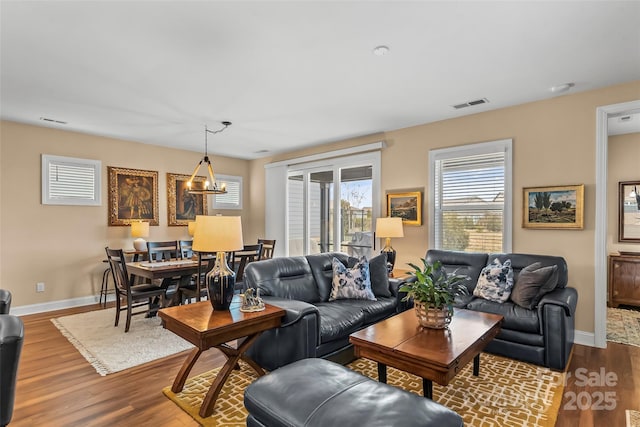 living room with wood-type flooring and a notable chandelier