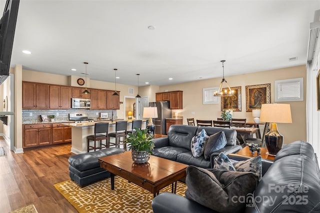 living room featuring dark hardwood / wood-style flooring and an inviting chandelier